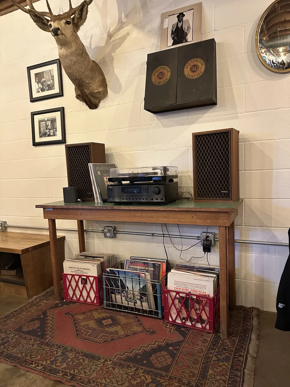 Record player station with deer mount, vinyl crates, and framed photos at Moon Wolf