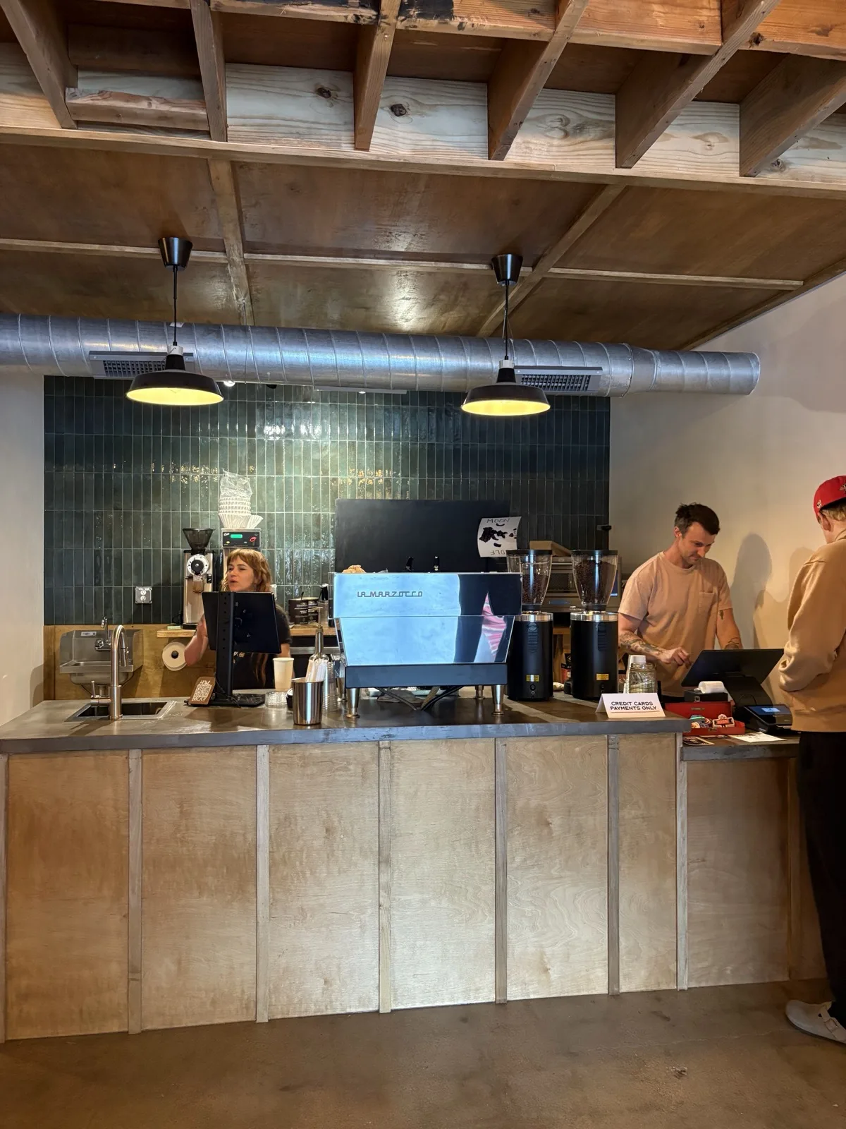 Industrial wood and green-tile coffee bar at Moon Wolf